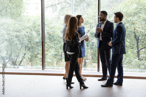 Fotografiet Group of multiethnic managers or employees standing in modern office hall after