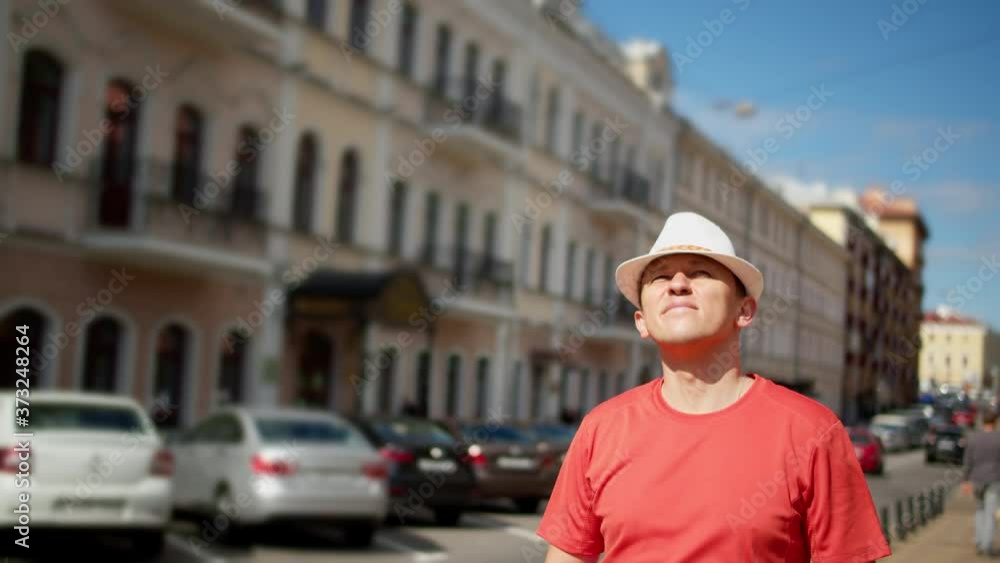 Portrait of a tourist in a hat and sunglasses walking along the streets of the city, tracking with a camera Portrait of a tourist in a hat and sunglasses walking along the streets of the city, tracking with a camera