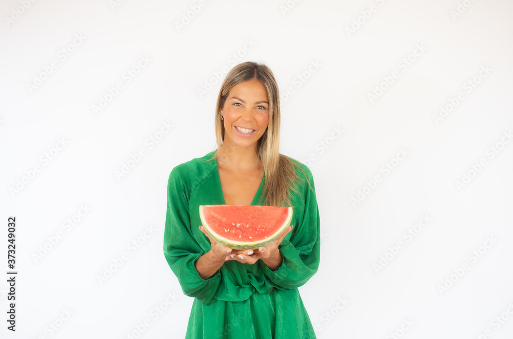 Beautiful woman in green dress with a watermelon smiling Beautiful woman in green dress with a watermelon smiling