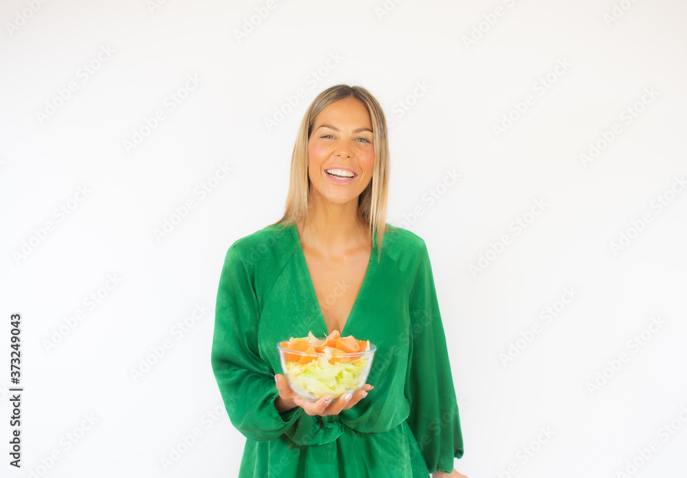 Beautiful woman in green dress with a salad smiling Beautiful woman in green dress with a salad smiling