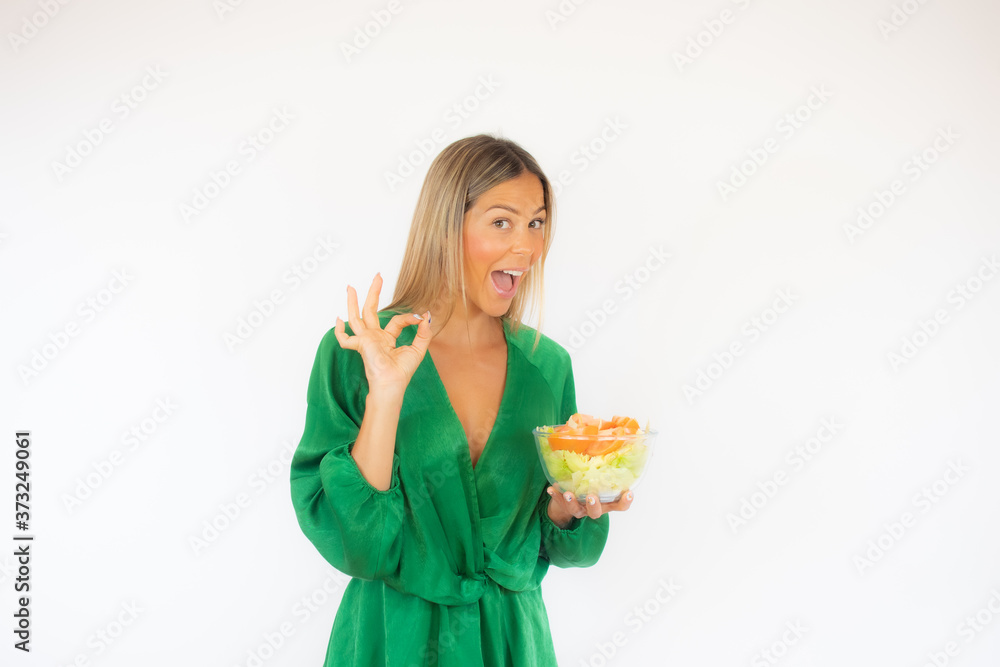 Beautiful woman in green dress with a salad smiling Beautiful woman in green dress with a salad smiling
