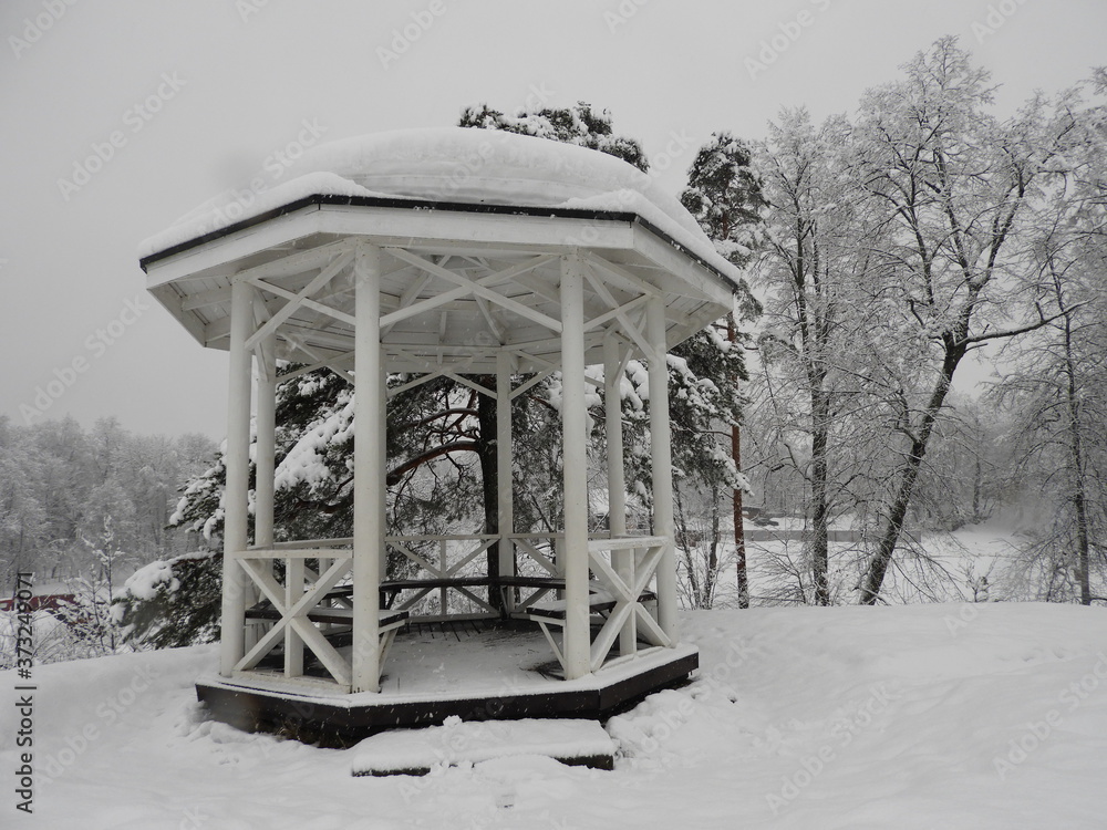 White Chinese style gazebo perched on a rock in winter in the snow White Chinese style gazebo perched on a rock in winter in the snow