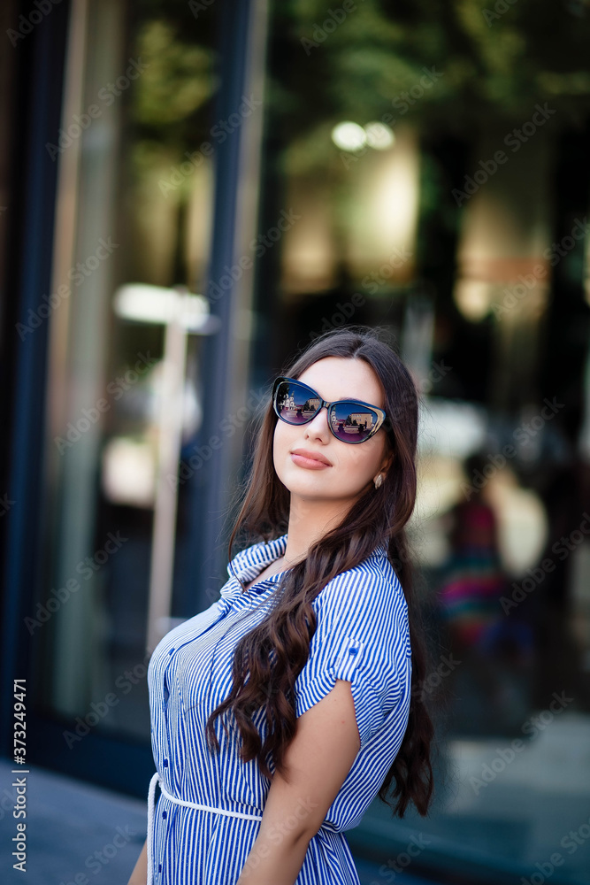 Young cute, crazy, big amazing smile, vintage outfit, sunglasses, staging downtown Europe, cute emotions. Portrait of a girl. Sunglasses on the girl.