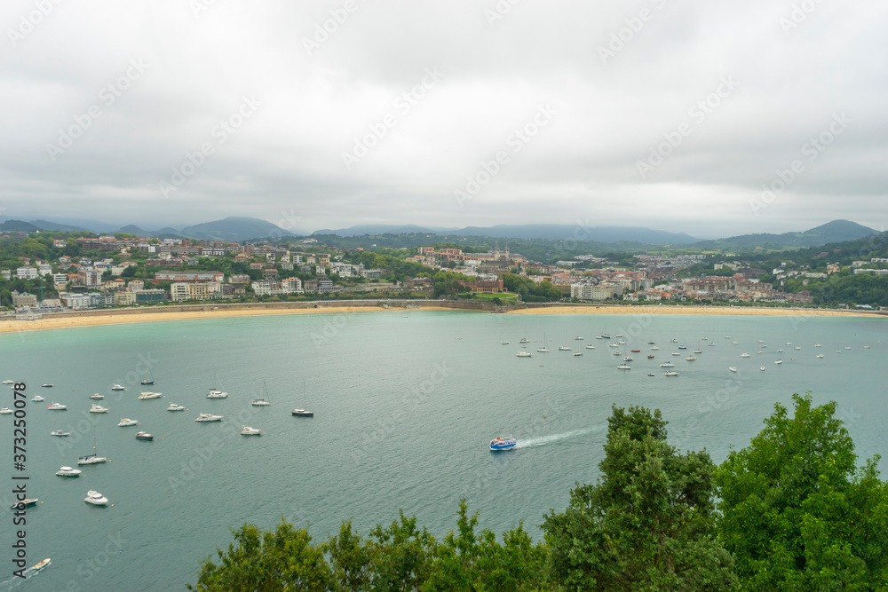 Holiday, view of the city of San Sebastian, with La Concha beach, from Mount Urgull. Summer vacation scene in Spain Holiday, view of the city of San Sebastian, with La Concha beach, from Mount Urgull. Summer vacation scene in Spain