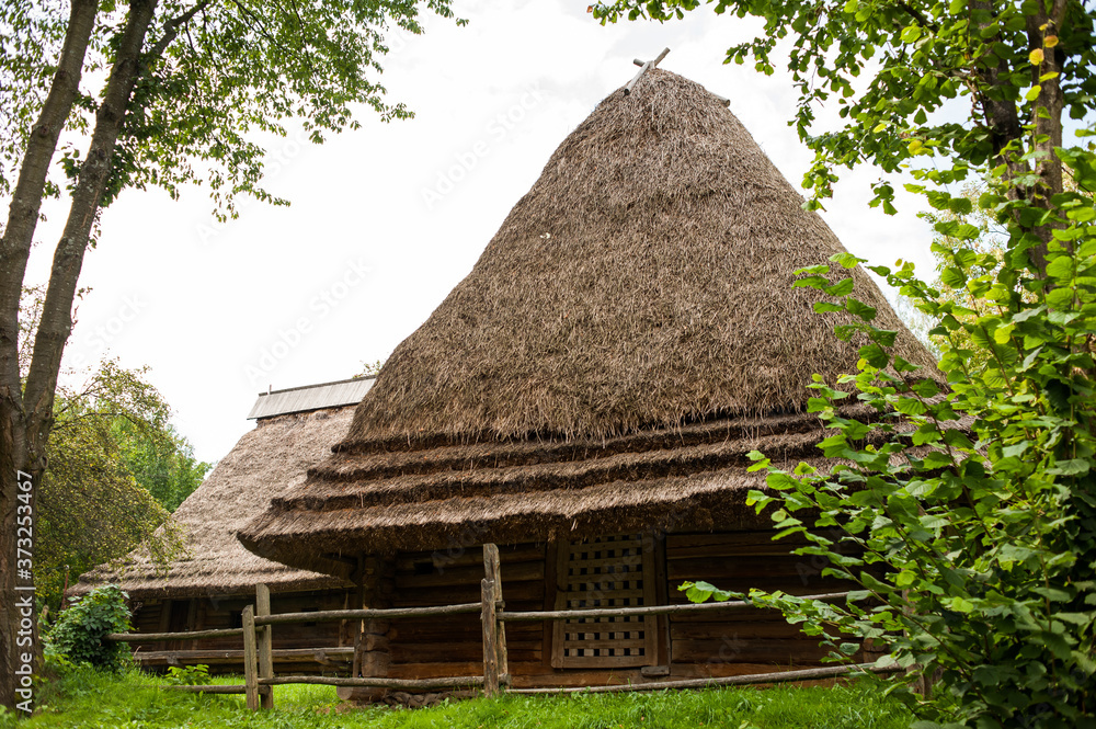 Old authentic wooden house with a thatched roof Old authentic wooden house with a thatched roof