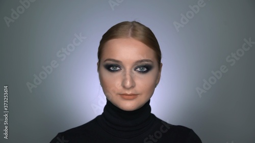 Beautiful woman with makeup smoky eyes posing at the camera