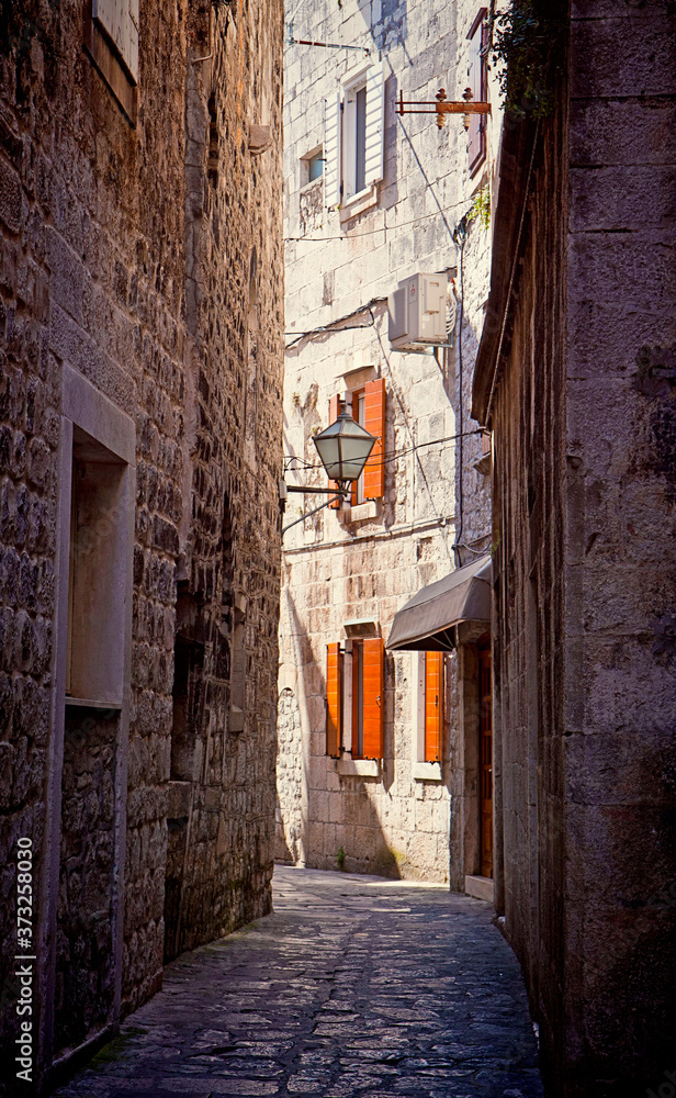 Croatia - Narrow medieval cobbled street in Trogir center, antique Dalmatian city founded 4000 years ago.