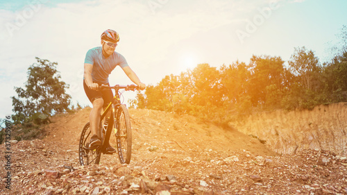 Man is riding bicycle, on the background of rocky trail in mountain area bike on trail at evening.mountain bike racing.healthy lifestyle.xtreme sports.vintage tone.selective focus.