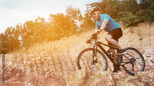 Man is riding bicycle, on the background of rocky trail in mountain area bike on trail at evening.mountain bike racing.healthy lifestyle.xtreme sports.vintage tone.selective focus. © mansong