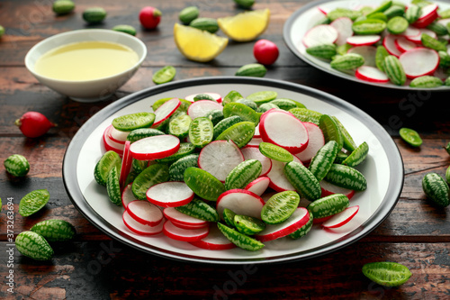 Cucamelon radish salad on rustic wooden table. healthy summer food