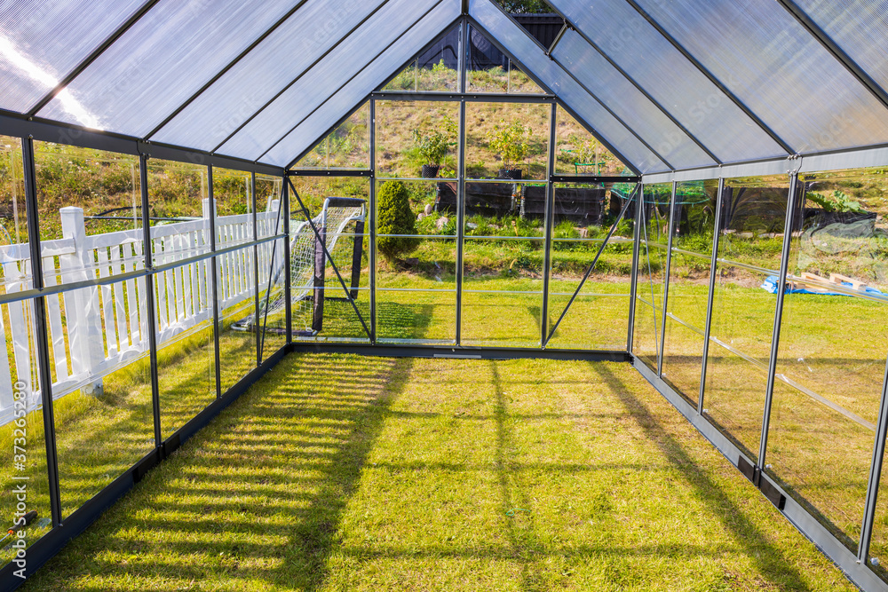 Beautiful view of newly built modern green house on back yard. Gardening concept. Beautiful view of newly built modern green house on back yard. Gardening concept.