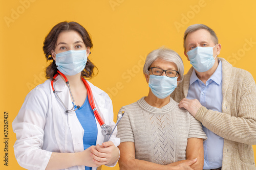 Doctor and senior couple wearing facemasks