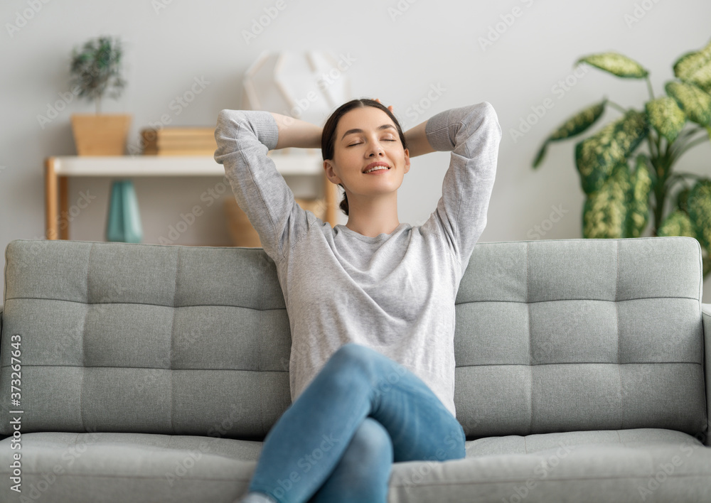 woman resting on sofa at home - obrazy, fototapety, plakaty 