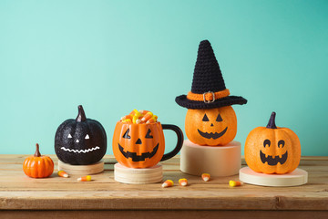 Halloween holiday concept with jack o lantern glitter pumpkin decor and candy corn on wooden table over blue background