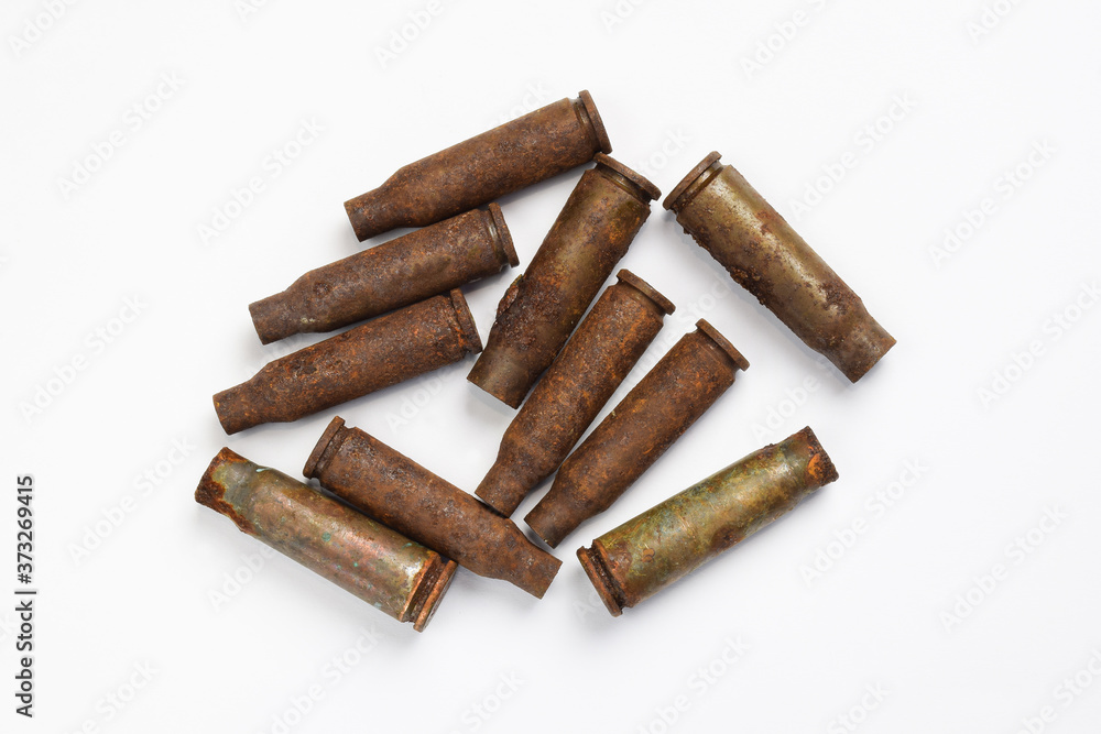 Ten rusty cartridges from a machine gun scattered on a white background Ten rusty cartridges from a machine gun scattered on a white background