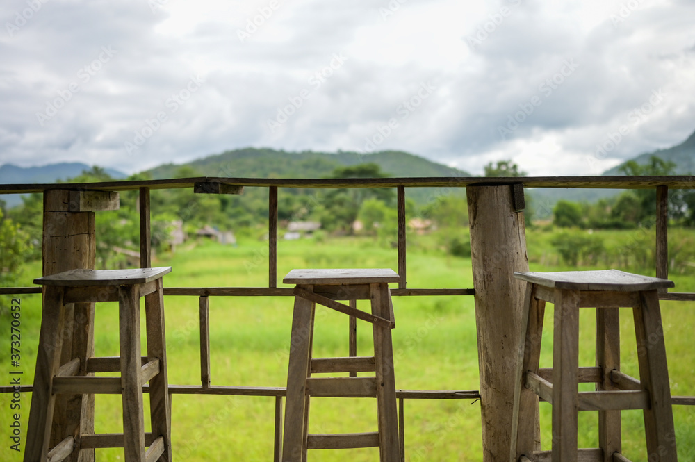 wooden table and chair for drink coffee and watching view of mountain farm landscape in sunlight