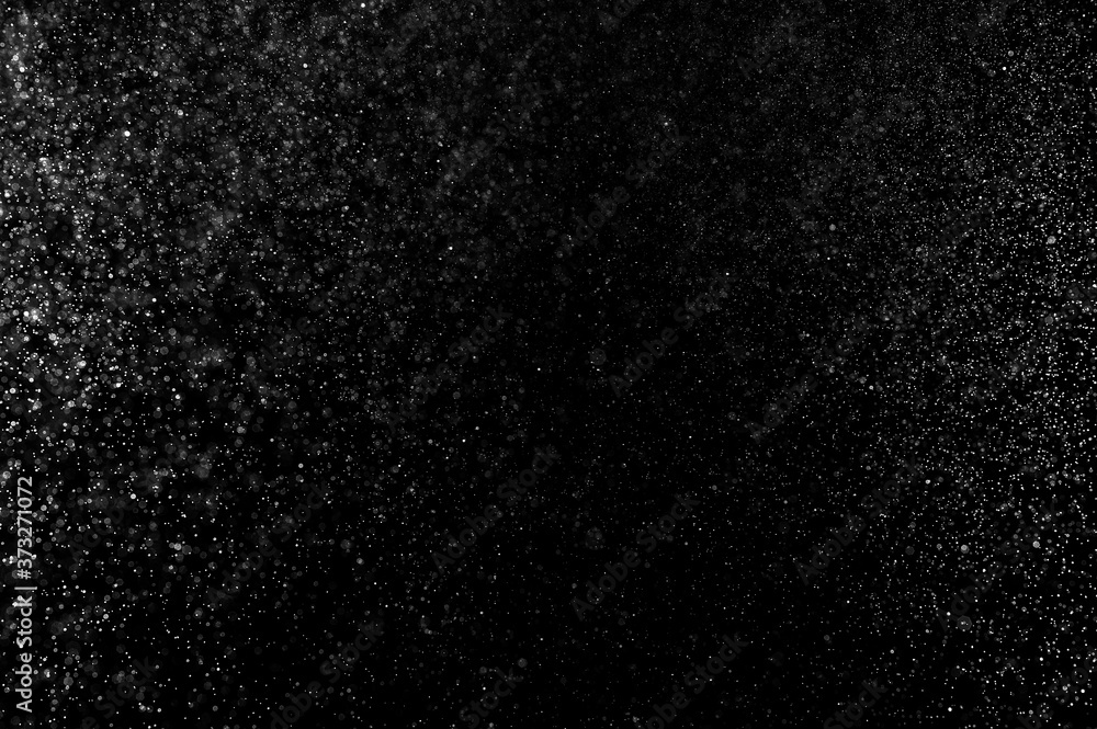 Obraz premium Abstract splashes of water on black background. Freeze motion of white particles. Rain, snow overlay texture.