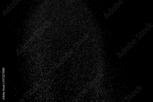 Abstract splashes of water on black background. Freeze motion of white particles. Rain, snow overlay texture.