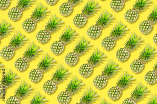 The texture colorful fruit pattern of pineapple fruit on yellow background, flat lay