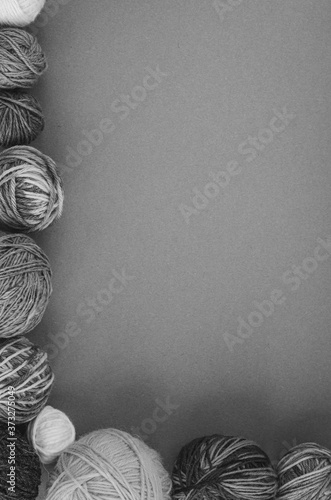 frame of various size and color woollen yarn balls, black and whita shot. Craft, knitting handmade concept. Top view, copy space. photo