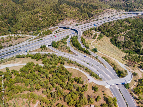 Thessaloniki, Greece aerial drone landscape of interchange traffic on Periferiaki inner ring road. Day top panorama of European multi-level stack highway junction with passing cars through forest. photo