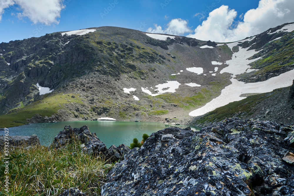 Obraz premium blue alpine lake formed from a glacier on top of a mountain