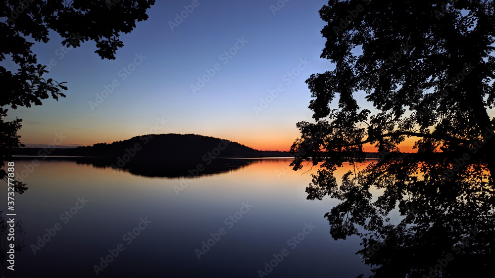 beautiful calm red landscape after sunset on the lake. End of the day. Beautiful landscape with a reservoir.
