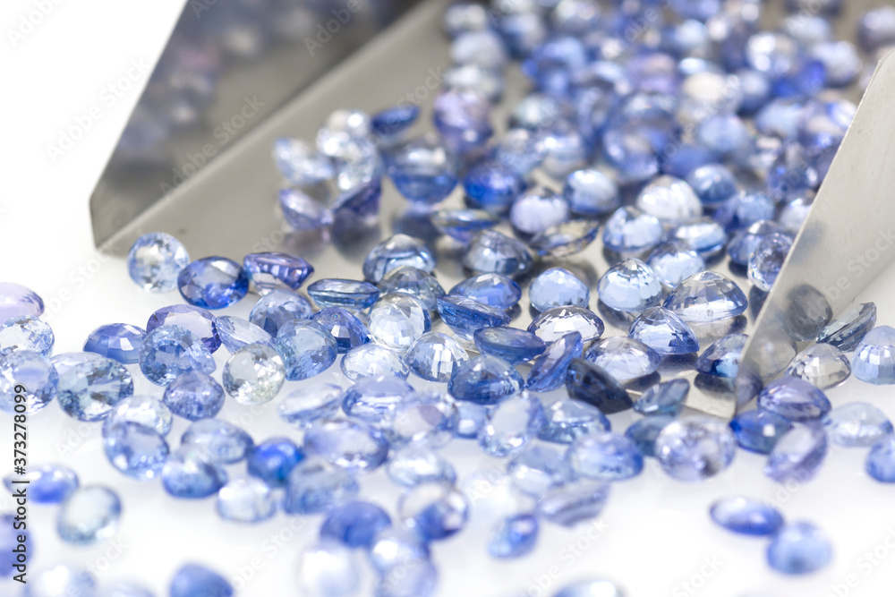 Precious blue sapphires on a jeweler's shovel. Precious polished stones. Set of many stones. Precious blue sapphires on a jeweler's shovel. Precious polished stones. Set of many stones.