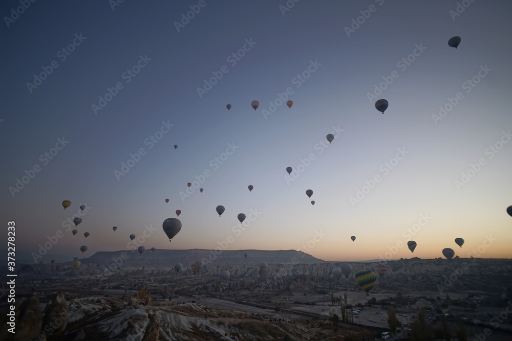 Hot air balloon flying over rock landscape at Cappadocia Turkey