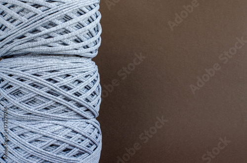 t-shirt yarn balls light gray color on brown background. Top view, copy space. Handmade craft recycle eco concept