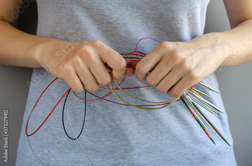 Woman hands holding a lot circular knitting needles