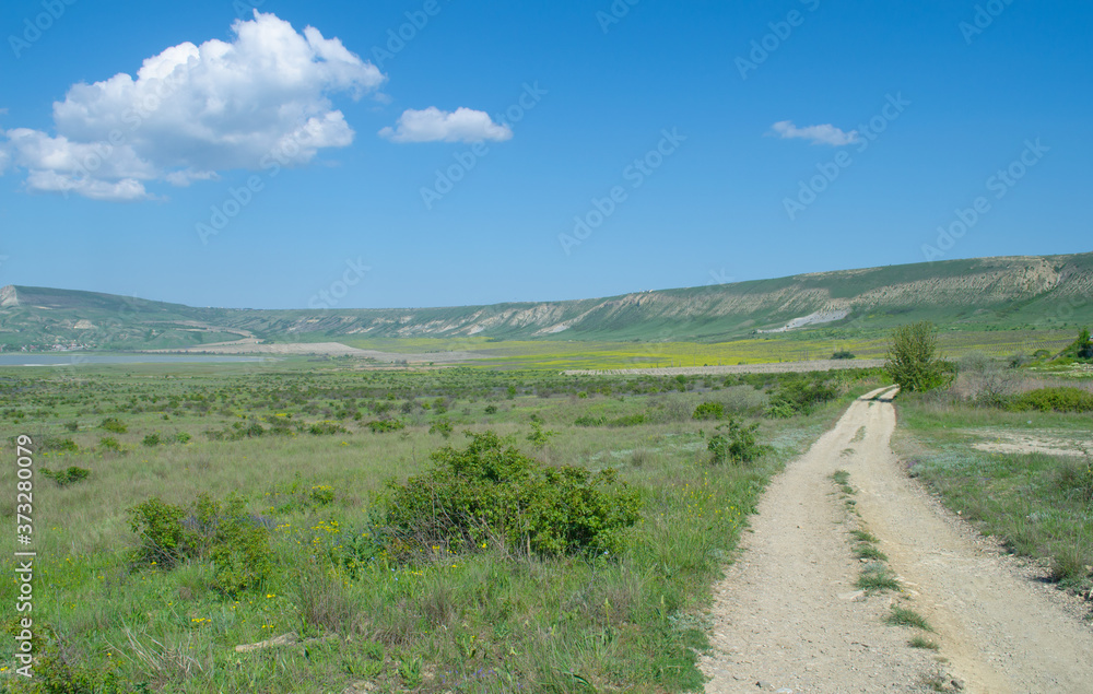 Picturesque road in the valley leads to the green rocks of Koktebel, Krim Picturesque road in the valley leads to the green rocks of Koktebel, Krim