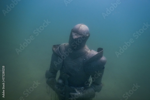 statue knight amor at the ground from a lake while diving