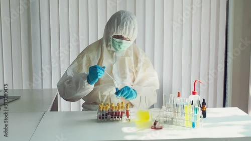 Researcher or scientists loads liquid sample into test tube in laboratory. Researchers are developing vaccines and medicine to treat the COVID-19 virus.