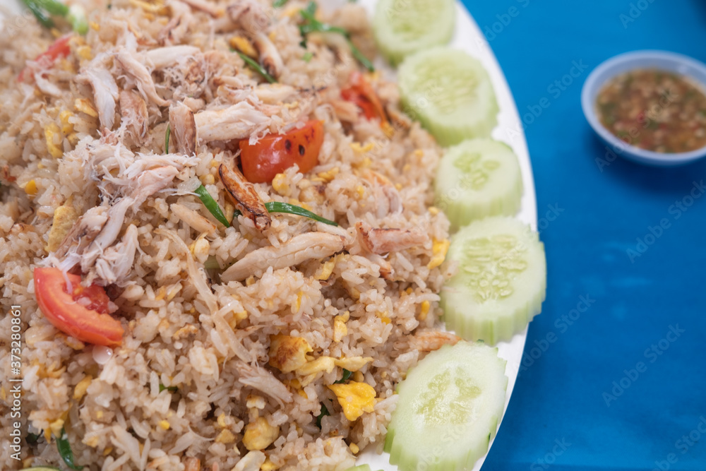 Fried rice with crab decoration with cucumber around plate.