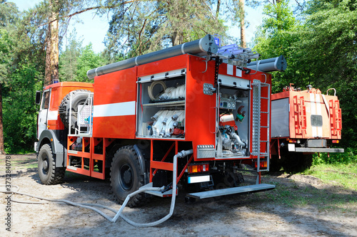 Canvas-taulu Fire engine parked in a forest, hoses connected, fire-fighting equipment prepare
