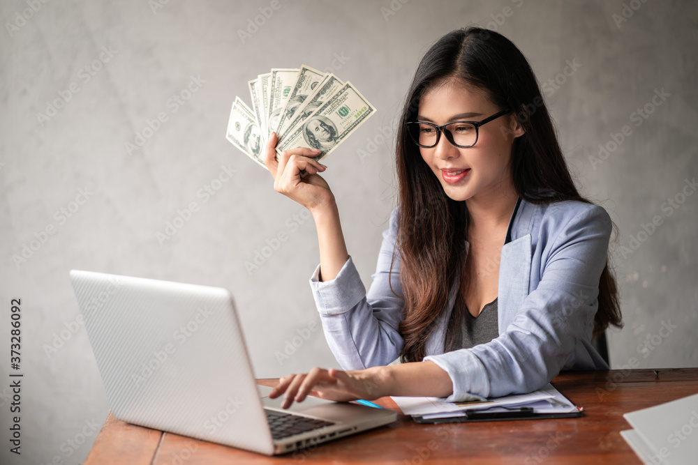 Dollar in a businesswoman hand. An Asia woman is working from home or office and glad to get dollar money from work and from a supplementary career or Part-time self-employment. Dollar in a businesswoman hand. An Asia woman is working from home or office and glad to get dollar money from work and from a supplementary career or Part-time self-employment.