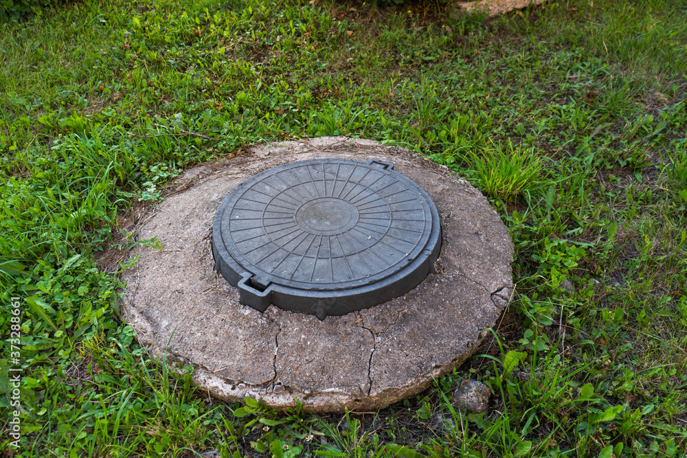 Manhole cover on the lawn in the Park
