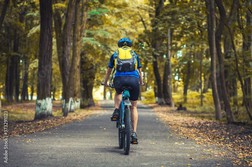Fototapeta Naklejka Na Ścianę i Meble -  woman cyclist rides mountain bike forest trails.