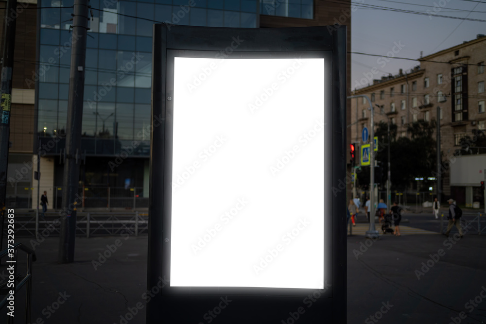 billboard in the city in the evening. Vertical advertising glowing billboard in the city in the evening. Vertical advertising glowing