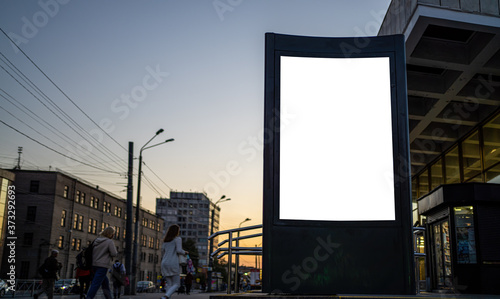 billboard in the city in the evening. Vertical advertising glowing