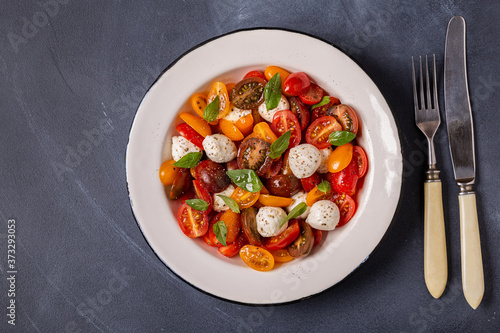 Traditional Caprese salad made of sliced fresh tomatoes, mozzarella cheese and basil