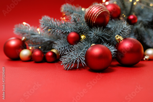 Winter holidays concept. Red  gold Christmas decorations on a red background with a Christmas tree  bokeh lights. Festive Christmas card. Happy New Year theme for layouts. Space for text. Horizontal