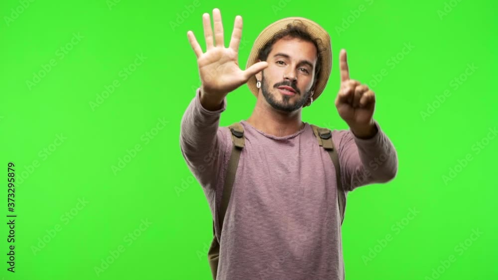 Young traveler man on chroma showing number nine Young traveler man on chroma showing number nine