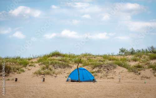 The tent is on the sand. Summer outdoor recreation near the sea.