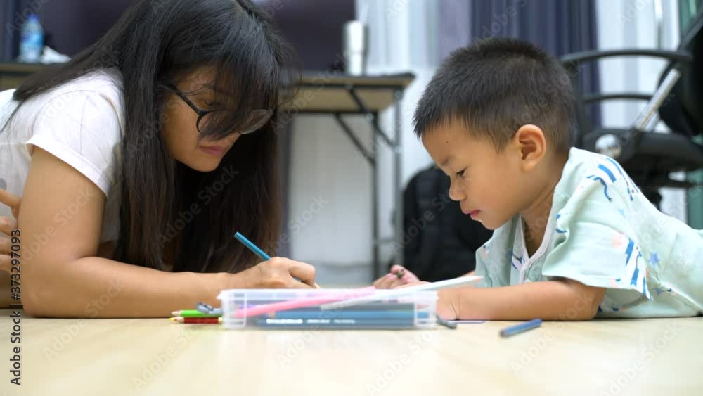 Asian boy about 3 year and 8 months drawing and painting picture by using color pencils with his mother Asian boy about 3 year and 8 months drawing and painting picture by using color pencils with his mother