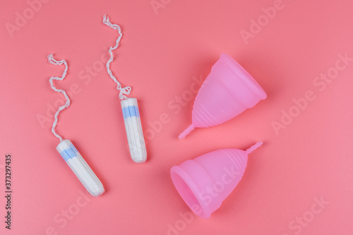 Female tampons and menstrual cups isolated on a pink background. Woman hygiene
