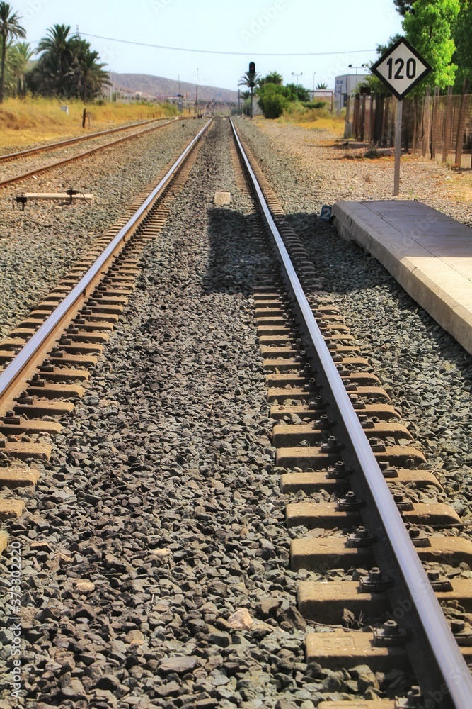 Obraz premium Speed sign limited to 120 km per hour next to train tracks
