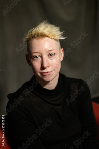 Portrait of a young woman with short blonde hair at ease.