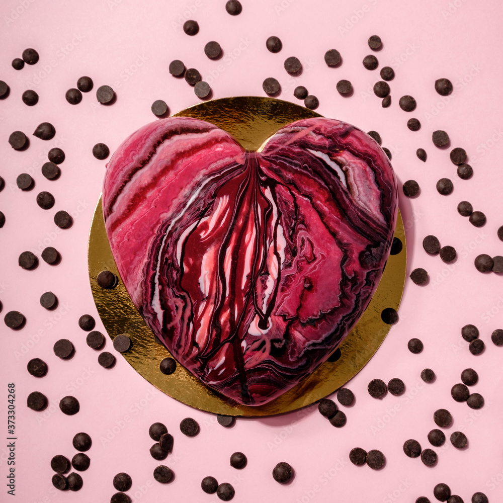 Obraz premium Valentine's Day concept. Creative Cheesecake heart candy with chocolate on pink background. Minimal flat lay style. Fruit pattern top view.